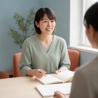 受講生との面談スペースでノートを開くキャリアカウンセラー